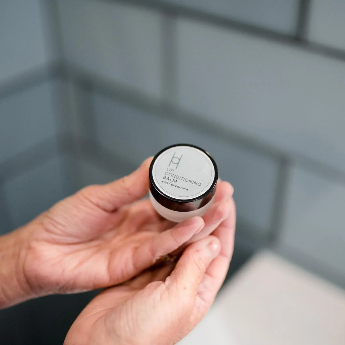 hand holding the harrogate organics lip conditioning balm
