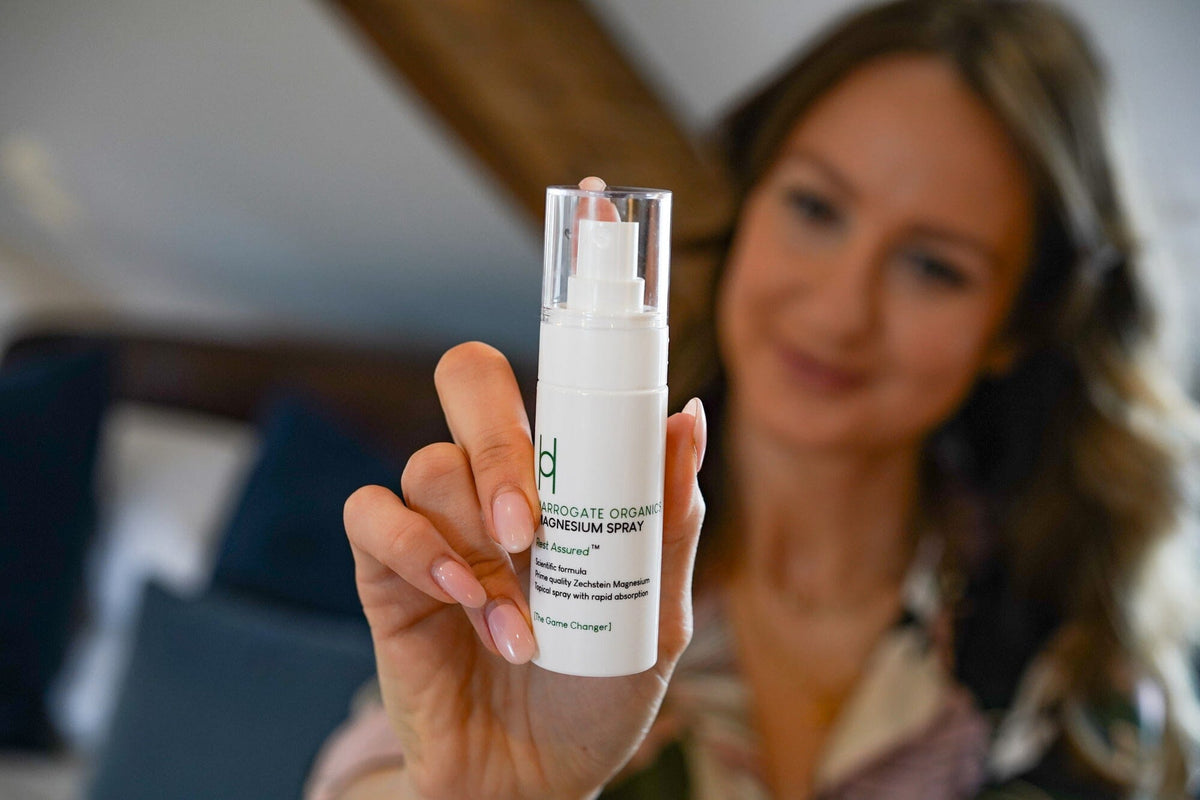 woman holding the harrogate organics magnesium spray with a blurred background
