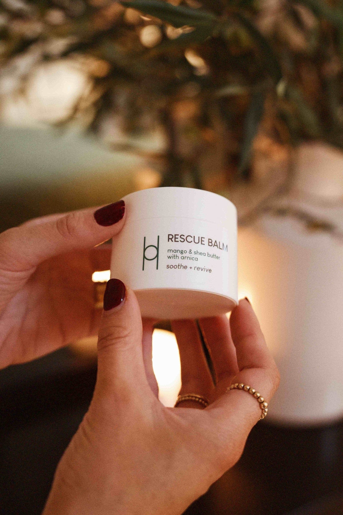 Pair of hands holding the Harrogate Organics Rescue Balm product
