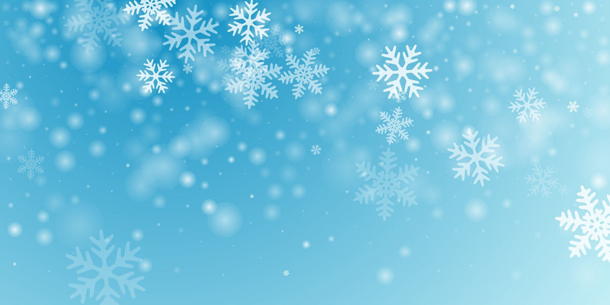 White snowflakes and soft light spots gently float against a gradient blue background, creating a festive and wintry atmosphere.