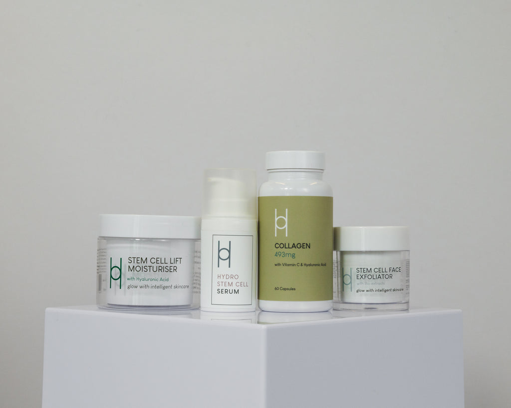 The Age Defying Set, featuring minimalist packaging, includes a stem cell lift moisturizer, hydro stem cell serum, collagen supplement bottle, and a stem cell face exfoliator—all designed for youthful-looking skin.