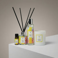The Deluxe Bliss Home Collection | Complete Aromatherapy Gift Set features an essential oil bottle, reed diffuser, spray bottle, and the signature Bliss candle, all labeled "Bliss Oudlamum Patchouli & Vetiver," displayed on a white surface.