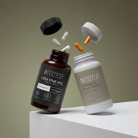 The Creatine HCL & Turmeric & Black Pepper Supplement Bundle is shown with both bottles open and capsules and tablets floating above them against a neutral background, both bottles angled as if suspended in mid-air.
