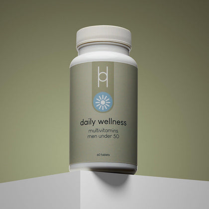 A bottle of Daily Wellness: Multivitamins for Men Under 50, with a gray and light blue design and 60 tablets, is displayed on a white surface against a gradient beige background. Provides essential vitamins and minerals.
