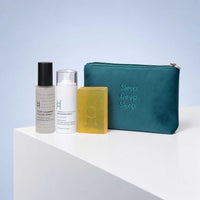 The Deep Sleep Gift Set – Magnesium Spray, Pillow Mist, Soap & Travel Pouch featuring a calming pillow mist, a magnesium spray, a rectangular soap bar, and a teal zippered pouch embroidered with Sleep. Deep. Sleep. on a white surface.