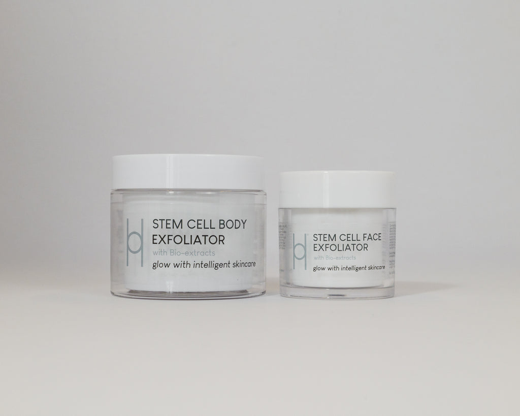 Two skincare containers with white lids, labeled Stem Cell Body Exfoliator and Stem Cell Face Exfoliator, are displayed side by side on a light surface as the Exfoliator Duo, designed to reveal radiant skin.