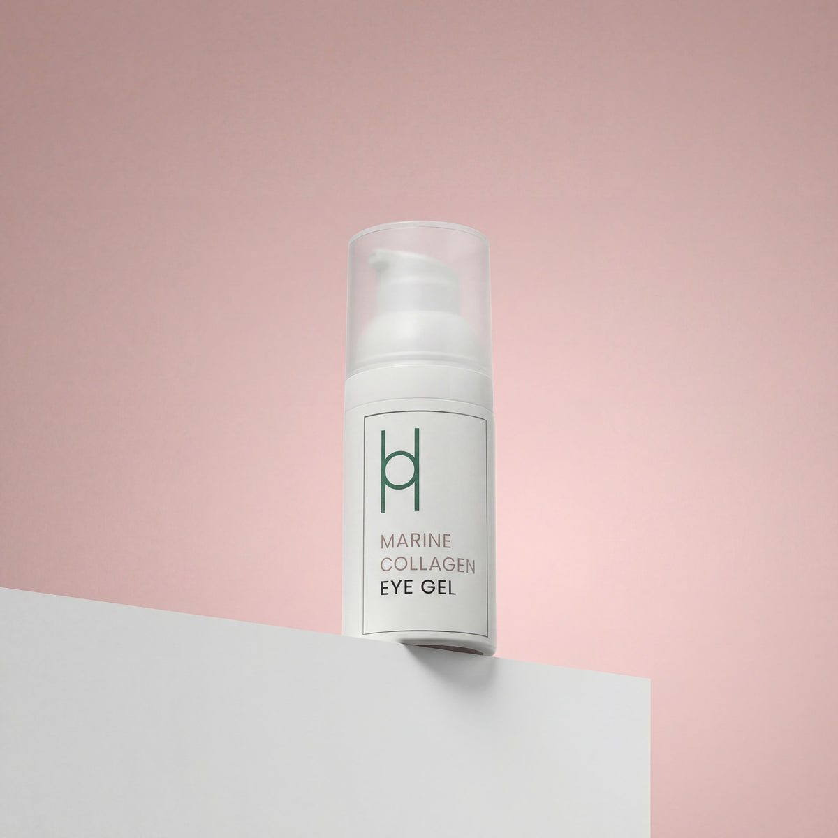 A white pump bottle of Marine Collagen Eye Gel with Hyaluronic Acid, Avocado Oil & Green Tea Extract (30ml) rests on a white surface against a pink background. Minimal green text notes its benefits for dark circles and puffiness, plus a simple logo.