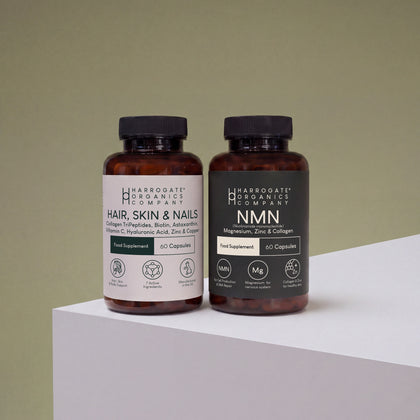 The Hair, Skin & Nails Complex and NMN Bundle from Harrogate Organics Company is displayed on a white surface against a light green background, highlighting premium supplements formulated to support NAD+ production and promote a healthy complexion.