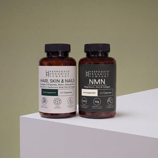 The Hair, Skin & Nails Complex and NMN Bundle from Harrogate Organics Company is displayed on a white surface against a light green background, highlighting premium supplements formulated to support NAD+ production and promote a healthy complexion.