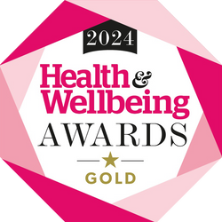 Logo for the 2024 Health & Wellbeing Awards Gold, with bold pink and black text inside a geometric shape featuring shades of pink and a gold star beneath the word GOLD.
