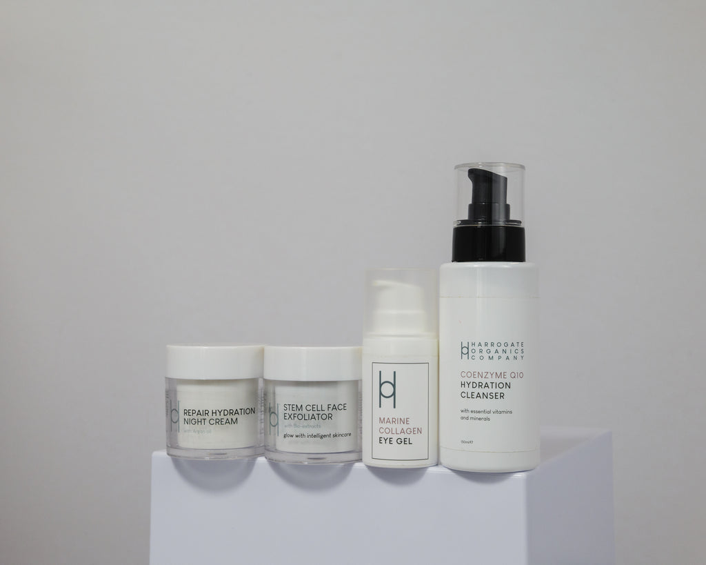 Four white containers of Men's Skin Reset are displayed on a white platform with a light gray background, featuring essentials for men: night cream, face exfoliator, eye gel, and cleanser in a pump bottle.
