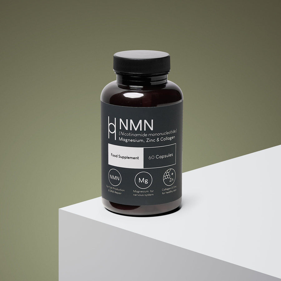 A brown bottle labeled "NMN, Magnesium, Zinc & Collagen Supplement 700mg NMN Per Serving - 30 Day Supply - 60 Capsules" sits on a white surface with a green gradient background, highlighting its wellness-support formula.
