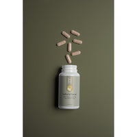 A white bottle of Natural Focus with L-Theanine 100mg and Caffeine 50mg sits on an olive green background, with seven brown capsules arranged in a circle above the open bottle.