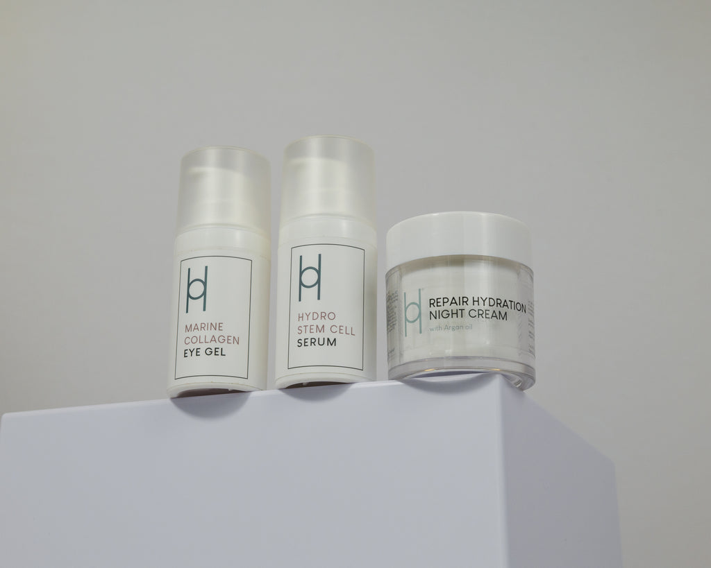The Overnight Repair Trio, featuring three skincare products in white containers, is displayed on a white surface with a light gray background.