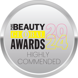 A circular silver badge displaying the text: Pure Beauty Global Awards 2024 Highly Commended. The words GLOBAL and 2024 are highlighted in yellow and pink, respectively.