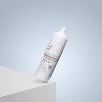 A white spray bottle of Harrogate Organics Sensitive Skin Magnesium Spray - 150ml angled on the edge of a white surface to aid sleep.