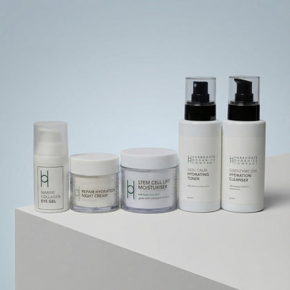 The Ultimate Men's Skincare Set | Complete 5-Piece Collection features five white, minimalist-labeled containers arranged in a row on a white surface with a light gray background, offering a full regimen for healthy skin.
