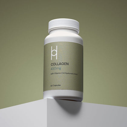 A white bottle of Marine Collagen 450mg with Vitamin C & Hyaluronic Acid Supplement (60 capsules, 60-day supply) is placed on a white platform against a muted green background.