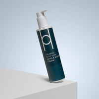 A bottle of Aloe Vera Hand & Body Cream with a pump is angled on a white platform against a light blue gradient background, ideal for moisturised and sensitive skin.